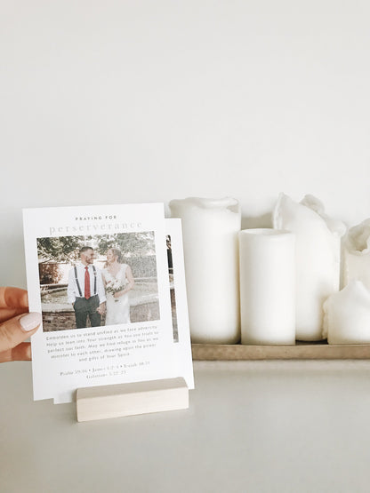 A set of 20 biblically-based prayer cards displayed in a home, personalized with a wedding or engagement photo for married, Christian couples to pray together for their 